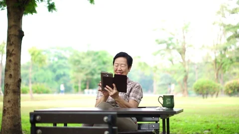 Asian senior laughing using pad for digital communication Stock Footage 82233691