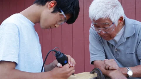 Asian Senior Man with Grandson Using Carving Tool Stock Footage 26513741