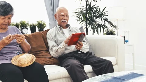 Asian senior man using tablet computer and Senior woman hand craft knitting wool Video stock 103420939