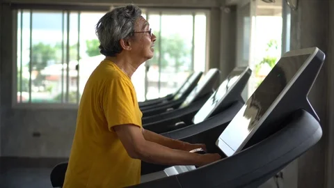 Asian Senior man walking exercise on treadmill workout in fitness gym . sport Stock Footage 112277467