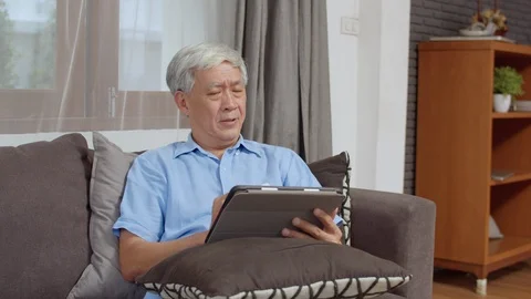 Asian senior men using tablet search information at home. Stock Footage 115061058