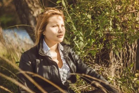 Asian sits alongside a tree Stock Photos