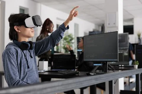Asian software developer using virtual reality goggles to code new server Stockfoto's