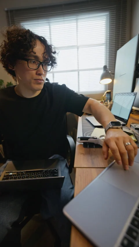 Asian Software Engineer Working on Multiple Laptops at Home Office Stock Footage 338424079