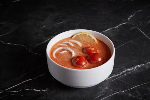 Asian soup with meat and seafood, plate close-up on a dark background Stock Photos