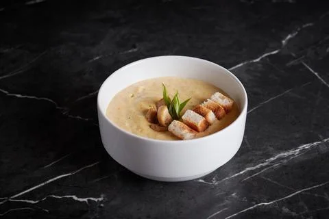 Asian soup with meat and seafood, plate close-up on a dark background Stock Photos