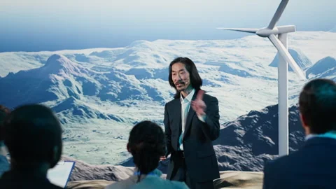 Asian speaker does wind energy presentation on stage featuring wind turbine Stock Footage 328263475