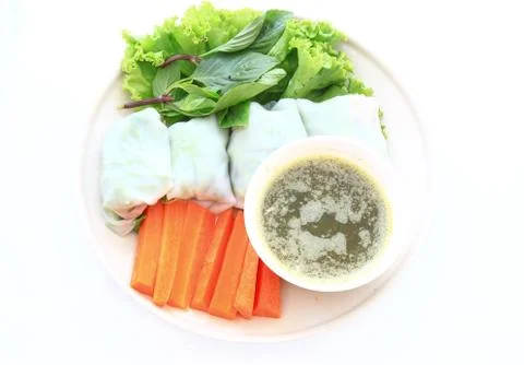 Asian spring rolls in rice paper on a wooden plate. Stock Photos
