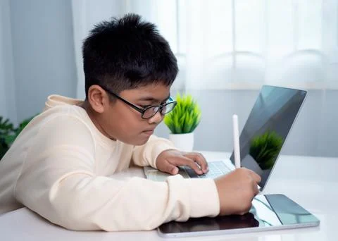 Asian student boy using computer and tablet learning. Educational of tech c.. Stock Photos