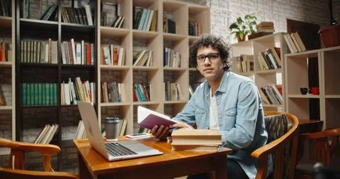 Asian student doing research in library using laptop in books, making a project 스톡 사진
