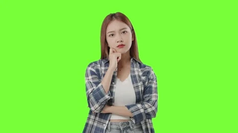 Asian student with doubtful face thinking on green background. Stock Footage 220896040