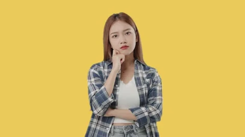 Asian student with doubtful face thinking on orange background. Stock Footage 220896279