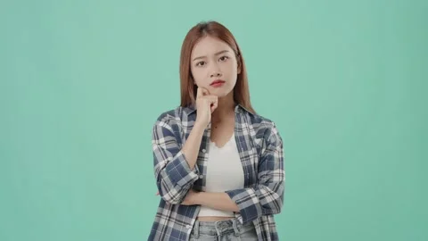 Asian student with doubtful face thinking on turquoise background. Stock Footage 220896613