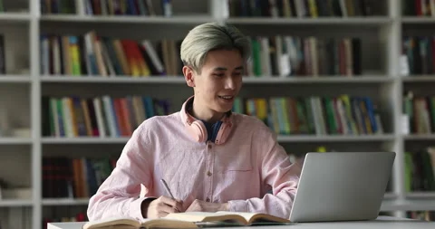 Asian student guy e-learning in library using modern tech Stock Footage 225511018