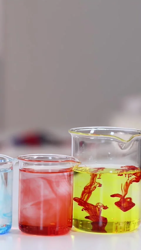 Asian Student in Lab Coat Performing Science Experiment with Colorful Beakers Stock Footage 340381128