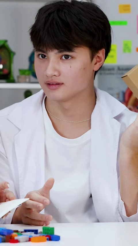 Asian Student in Lab Coat Presenting Project with Cardboard Box Stock Footage 342309212