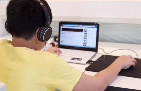 Asian student operating computer in school