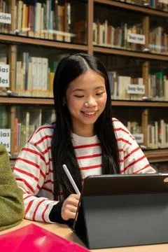 Asian student using digital tablet learning in library Stock Photos