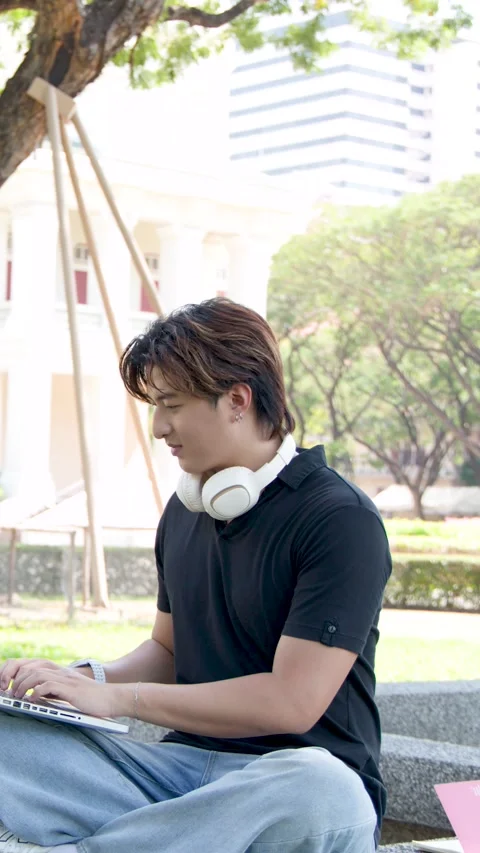 Asian Student Using Laptop Outdoors on University Campus in Bangkok Stock Footage 337600466