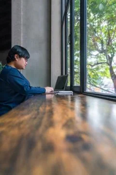 Asian student using laptop at rustic garden view coffee Stock Photos
