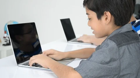 Asian students boy using laptop learning in the classroom at school Stockbeeldmateriaal 105148734