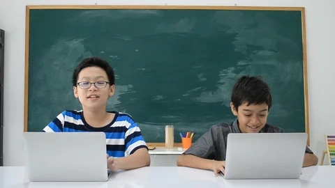 Asian students boy using laptop learning in the classroom at school Stockbeeldmateriaal 105148782