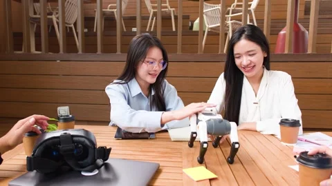 Asian Students Collaborating and Testing a Robot Dog on Campus Table Stock Footage 346582069