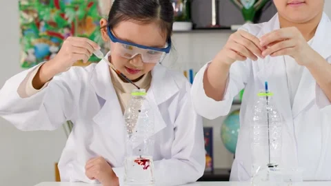 Asian Students Conducting Science Experiment with Liquid Droppers in Laboratory Stock Footage 335610353