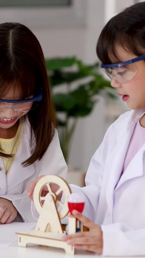 Asian Students in Lab Coats Experimenting with Wooden STEM Toy Stock Footage 339870202