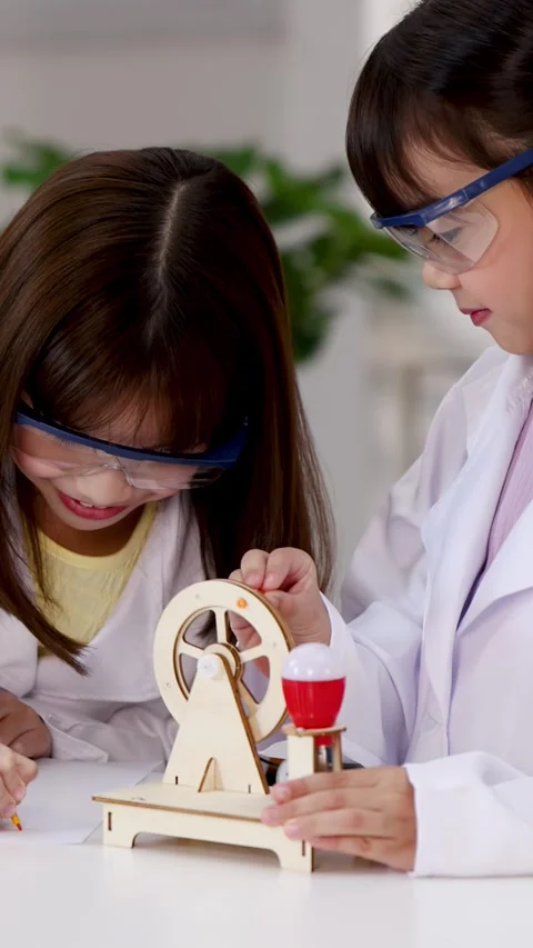 Asian Students in Lab Coats Experimenting with Wooden STEM Toy Stock Footage 339870305