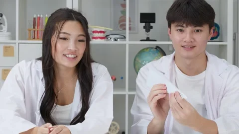 Asian Students in Lab Coats Throwing Paper Airplane in Science Classroom Stock Footage 342473441