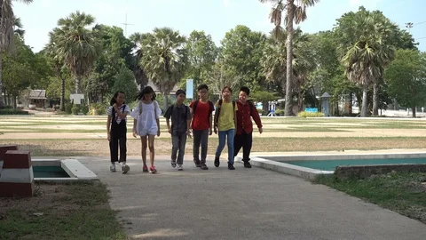 Asian students running and jumping after school in the park together Stockbeeldmateriaal 89127754