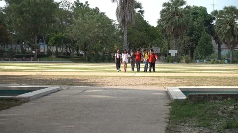 Asian students running and jumping after school in the park together Stockbeeldmateriaal 89128722
