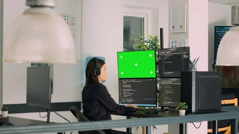 Asian system engineer programming app code on monitors with greenscreen 스톡 사진