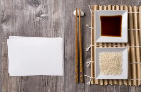 Asian table with chopsticks, soy sauce and rice and white note Stock Photos