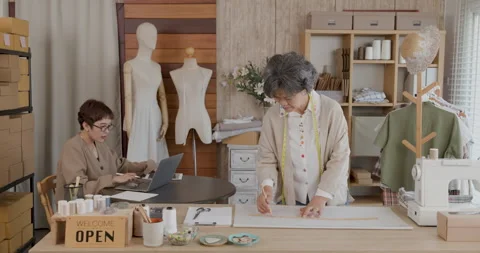 Asian Tailors Managing Custom Online Orders In Creative Workshop Medium Shot Video stock 340134165