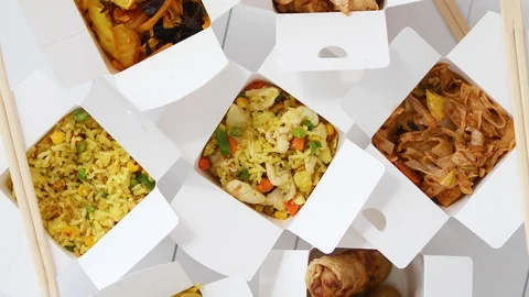 Asian take away or delivery food concept. Paper boxes placed on white wooden Stock Footage