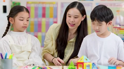 Asian Teacher and Children Learning Geometry with 3D Shapes in Classroom Stock Footage 325838924