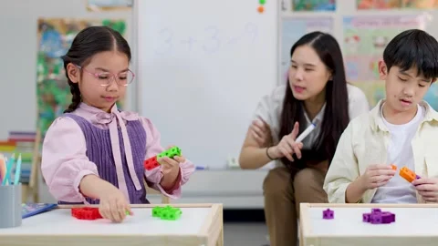 Asian Teacher and Elementary Students Learning Arithmetic with Math Cubes Stock Footage 328208690