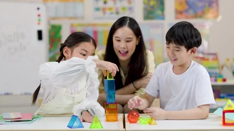 Asian Teacher and Primary Students Learning Geometry with 3D Shapes in Classroom Stock Footage 325838952