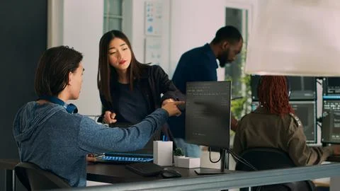 Asian team of IT engineers analyzing html code on terminal window Stock Photos