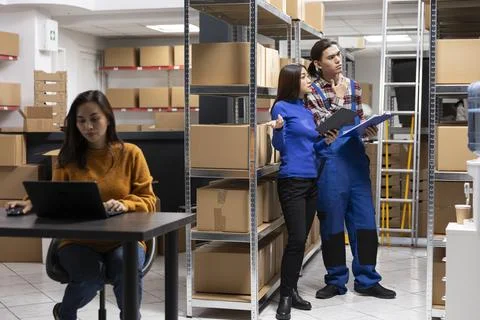 Asian team of workers in a depot checking the packages for shipment logistics Stock Photos
