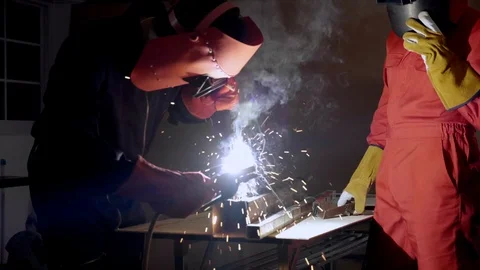 Asian technicians are using machines to weld steel, resulting in sparks. Stock Footage 124323955