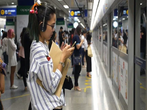 Asian Teen Girl Using Mobile Phone at Subway Platform Waiting For Train. Stock Footage