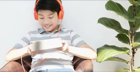 Asian teens playing tablet computer with smile face . Stock Photos