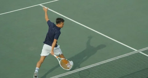An Asian Tennis Player backhand shot and sets up for the return. Vídeo Stock 101283003