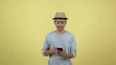 Asian Thai using smart phone for shopping on line on yellow background Stock Footage 120900611