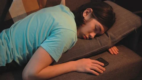 Asian Tired  Guy Is Sleeping at The Sofa, phone in hand Stock Footage 148347797
