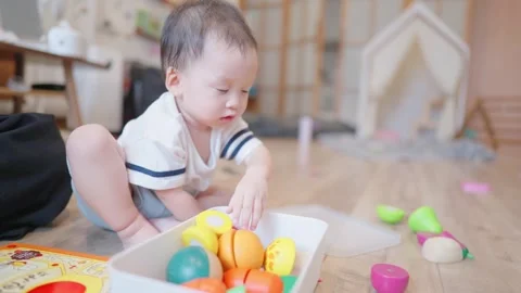 Asian toddler boy sitting inside the living room playing with toys on the floor Stock Footage 279505978