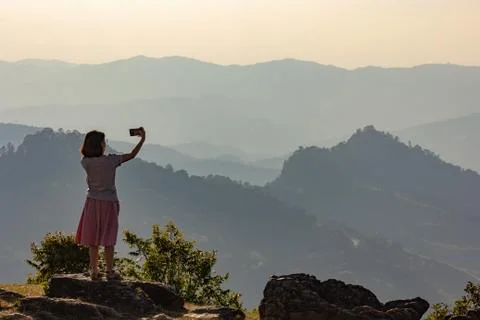 Asian tourist enjoying selfie from top of the mountain with valley view Stock Photos